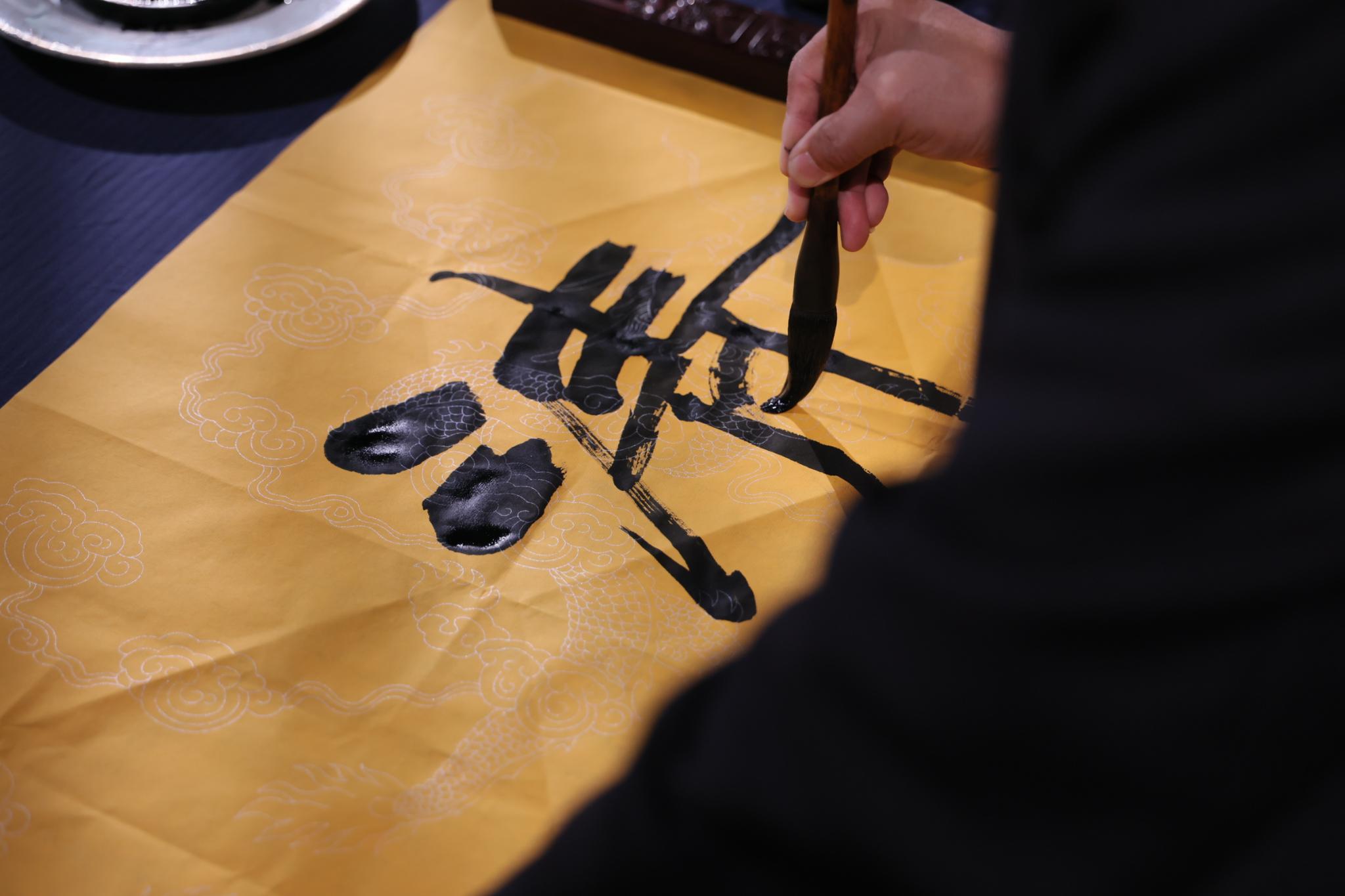 书画名家在龙纹宣纸上挥毫题字 免费题写牌匾