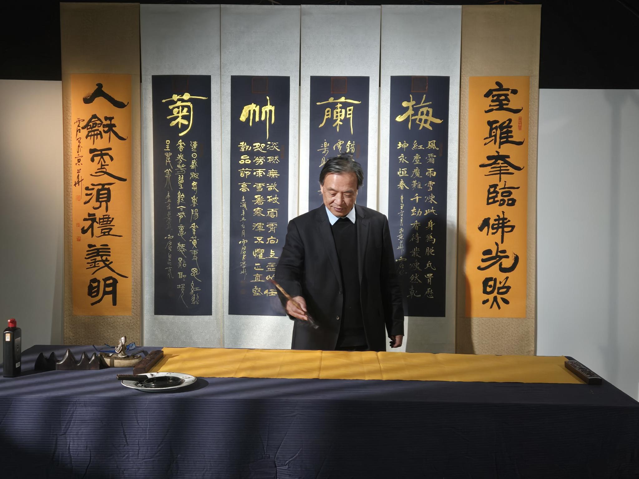 书画名家在梅兰竹菊四条屏前挥毫书写
